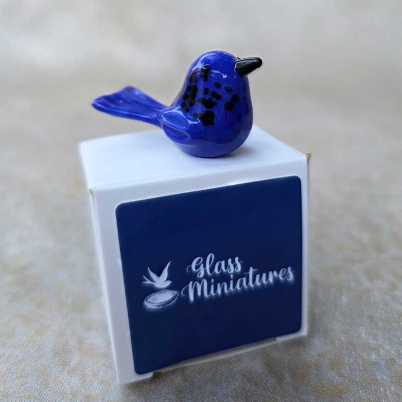 The Chic Nest handblown blue glass wren miniature figurine perched on top of its small white gift box